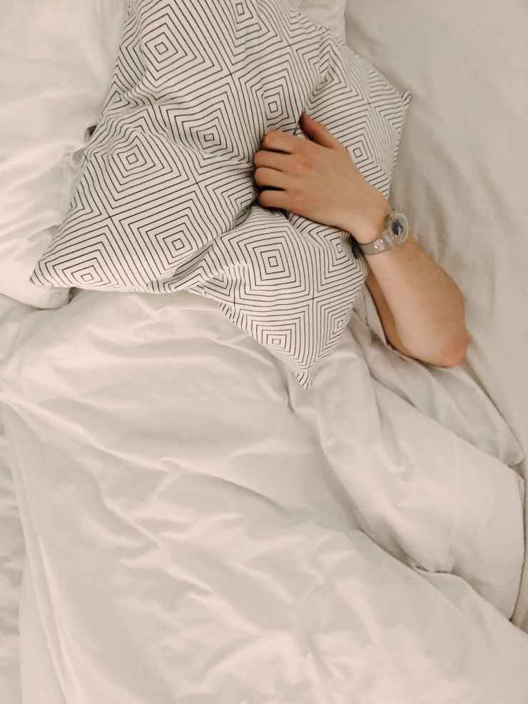 person holding gray and white throw pillow